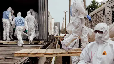 موظفي اللجنة الدولية للصليب الأحمر وهم يُفرّغون ما يُقال إنها جثث مواطنين أوكرانيين، بينهم عسكريون، أعادتهم روسيا