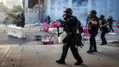 ضباط شرطة لوس أنجلوس يهاجمون المتظاهرين أمام مبنى بلدية لوس أنجلوس خلال احتجاج على حملات الهجرة الفيدرالية