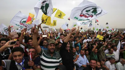 عراقيون يلوحون بأعلام ميليشيات