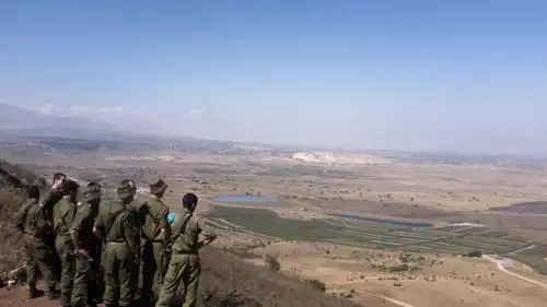 جنود إسرائيليون ينظرون إلى الجانب السوري من هضبة الجولان