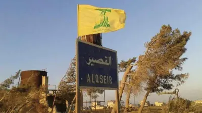 شاخصة لمدينة القصير ويبدو علم حزب الله 