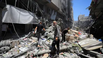 فلسطينيون على أنقاض المنازل المدمرة في قطاع غزة